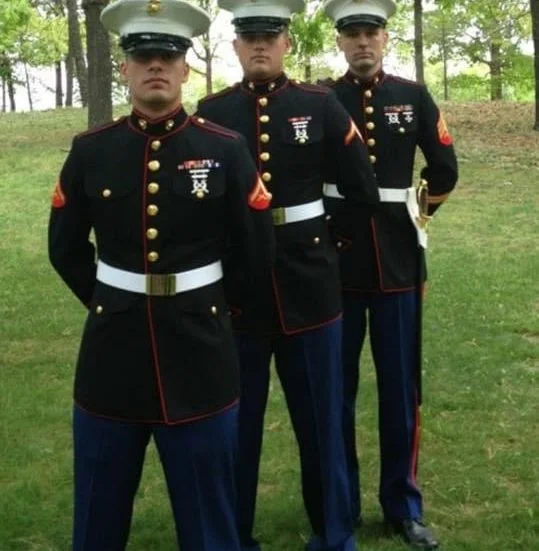 Three Veterans in uniform standing next to each other, with a bulldog.