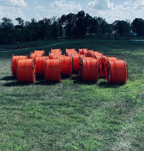 A field of orange HDPE conduits.