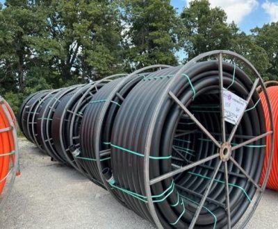 A group of standard HDPE conduits in a variety of sizes in a parking lot.